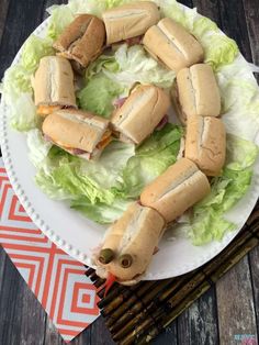 a white plate topped with sandwiches on top of lettuce