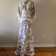 a white dress on a mannequin head stand in front of a gray wall