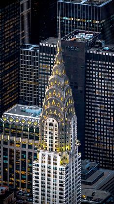 an aerial view of the chrysler building in new york city at night, with skyscrapers lit up