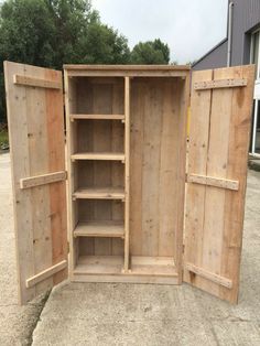 an open wooden cabinet sitting on top of concrete