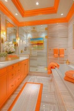 an orange and white bathroom with two sinks, tub, and shower stall in it