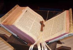 an open book with a wooden cross on it