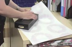 someone is wrapping gifts in a box on top of a desk with papers and binders