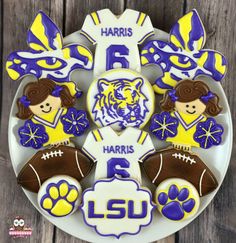 decorated cookies are arranged in the shape of lsu football players and their name on a plate