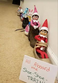 there are several elfs lined up on the floor next to a sign that says, all aboard the shoe - shoe train