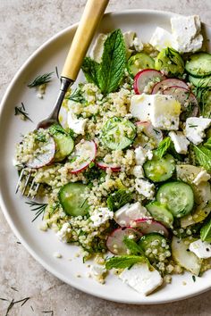 a white plate topped with cucumber, radishes and feta cheese