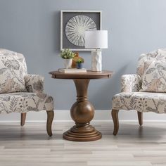 a living room with two chairs and a table in front of a blue painted wall