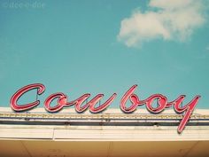 the word cowboy written in red on top of a building