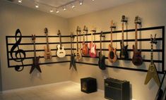 guitars and amps are hanging on the wall in a music room with white tile flooring