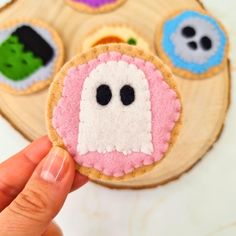 a hand holding a cookie decorated to look like a ghost