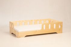 a small wooden bed with no sheets on it