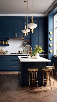 a kitchen with blue cabinets and gold stools next to a large window that has lights hanging from the ceiling