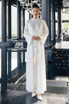 Indulge in luxury with the Ao Dai. This elegant and exclusive piece features stunning sequins and wide sleeves, creating a sophisticated look. Perfect for special occasions, its floor-length design will have you feeling like a fashion icon. Length: - Ao Dai: 130cm/135cm/140cm (S/M/L)- Pants: 100cm/104cm/108cm (S/M/L) *Including synthetic silk pants of the same color as the photo. White Long Sleeve Gown With Sequins, White Long Sleeve Sequin Gown, Elegant Floor-length Sequin Dress For Festive Occasions, Festive Floor-length Sequin Dress, Elegant Abaya With Sequins For Party, Elegant Sequined Abaya For Party, White Long Sleeve Sequin Dress For Wedding, Elegant Sequined Evening Abaya, White Long Sleeve Sequin Wedding Dress