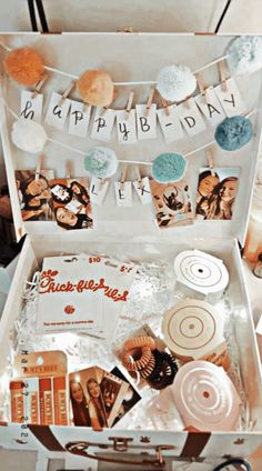 an open suitcase filled with pictures and other items for a happy birthday party or baby's first birthday