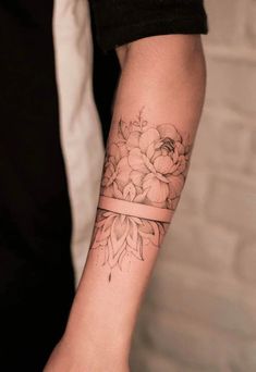 a woman's arm with flowers and a ribbon on the wrist that is wrapped around it