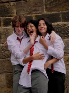 three young people are hugging and laughing together