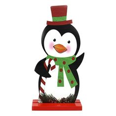 a snowman with a green scarf and hat is standing on a red base holding a candy cane