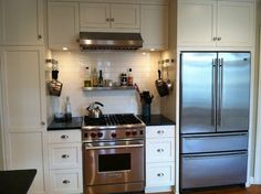 a kitchen with stainless steel appliances and white cabinets