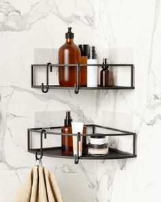 two black shelves with soap, lotion and other items on them against a marble wall