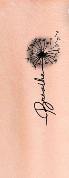 a dandelion tattoo on the back of a woman's left arm with writing underneath it