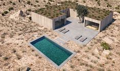 an aerial view of a house in the desert with a pool surrounded by plants and rocks