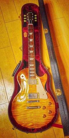 an electric guitar laying on top of a hard wood floor