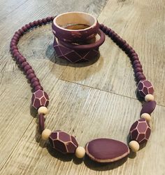 a giraffe print beaded necklace and cup on a wooden table