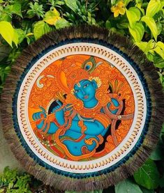 a decorative plate with an image of a god in the center surrounded by greenery