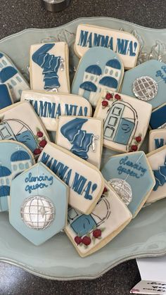 decorated cookies in the shape of houses and umbrellas are on a blue platter