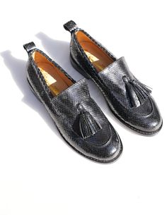 Slip into luxury with these Le Sapeur loafers from our L’Artisane collaboration. Made from locally-sourced snakeskin leather, they were skillfully constructed and dyed entirely by Senegalese hands– resulting in the rich black patina you see here. The tassels add a distinguished touch. Slips onHeel Height: 2 in/5 cmHandcrafted in Senegal Black Loafers, Black Slip Ons, Holiday Collection, Snake Skin, Patina, Tassels, Heel Height, Loafers, Slip On