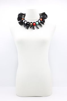 a white mannequin with a black and red necklace on it's neck