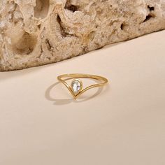 Our Diamond Pear Drop Chevron Ring features a bezel-set pear diamond, radiating brilliance. Framed by the graceful curve of the chevron motif, this ring exudes sophistication and modern allure. Its unique blend of classic charm and contemporary flair makes it a versatile statement piece that elevates any ensemble, from casual to formal occasions. - Made in 14k Solid Gold - Decorated with handset 0.17ctw white diamond - Diamond Color and Clarity: G Color SI clarity - Band Width: 0.95 mm / 0.04 inches - Top Width: 7.72 mm / 0.30 inches - Thickness: 1.30 mm / 0.05 inches - This product comes with iconic Norm Jewels gift box Modern Teardrop Rings With Rose Cut Diamonds, Modern Teardrop Diamond Ring For Formal Occasions, Modern Teardrop Diamond Ring For Formal Events, Elegant White Drop-shaped Rings, Elegant Teardrop Ring With Single Diamond, Elegant Teardrop Single Diamond Ring, Modern Rose Cut Pear-shaped Diamond Rings, Elegant Teardrop Bezel Set Ring, Elegant Pear-shaped Ring With Single Diamond