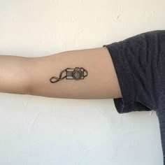 a person's arm with a camera tattoo on the left side of their arm