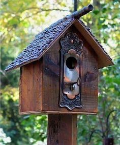 a wooden birdhouse with a metal door and window