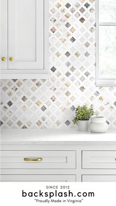 a kitchen with white cabinets and tile backsplash