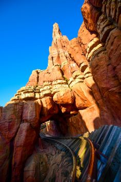 an image of a train going through a tunnel in the rocks at disney's animal kingdom