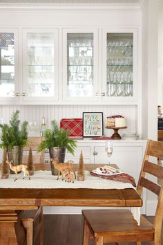 a dining room table with christmas decorations on it and two small deer figurines