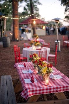 a table with red and white checkered cloth on it is set up for an outdoor event