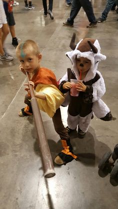 two young boys dressed up as animals and one is holding a stick in his hand