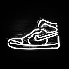 a neon sign with a shoe on it's side in black and white colors