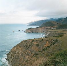 an ocean view with mountains in the background