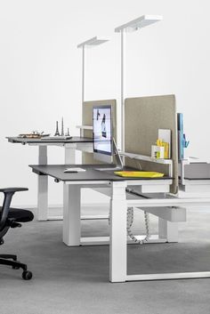 an office desk with two computer screens on it and a chair in the foreground