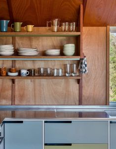 the shelves are filled with dishes and cups