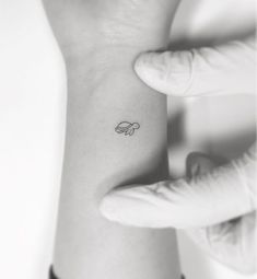 a small wrist tattoo with an elephant on it's left arm, in black and white