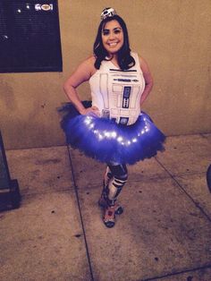 a woman dressed up as r2d2 is standing in front of a building