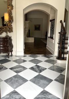 an entry way with a checkered floor and mirror