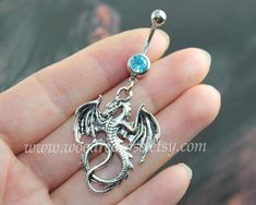 a silver dragon belly ring with a blue stone in it's center, on a person's finger