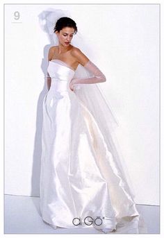 a woman in a white wedding dress posing for a photo with her hand on her shoulder