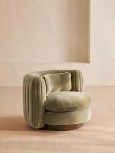 a round chair sitting on top of a hard wood floor next to a white wall