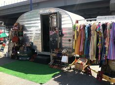 an airstream with clothes on display in front of it